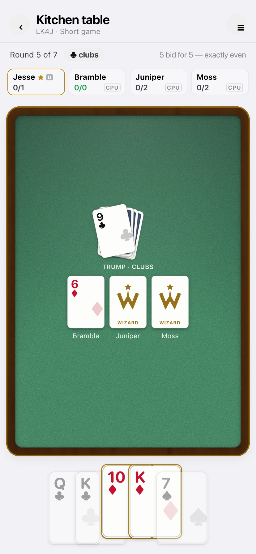Wizard: round five, hearts are trump, three cards on the green table and your fan of cards below, a Wizard among them